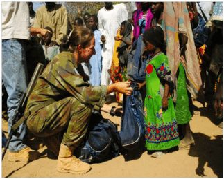 Lieutenant Karen O'Sullivan presenting the locals of Ridjil Doud, in Chad with the Friends of St. Patrick Aid. (Photograph courtesy of the Defence Forces)